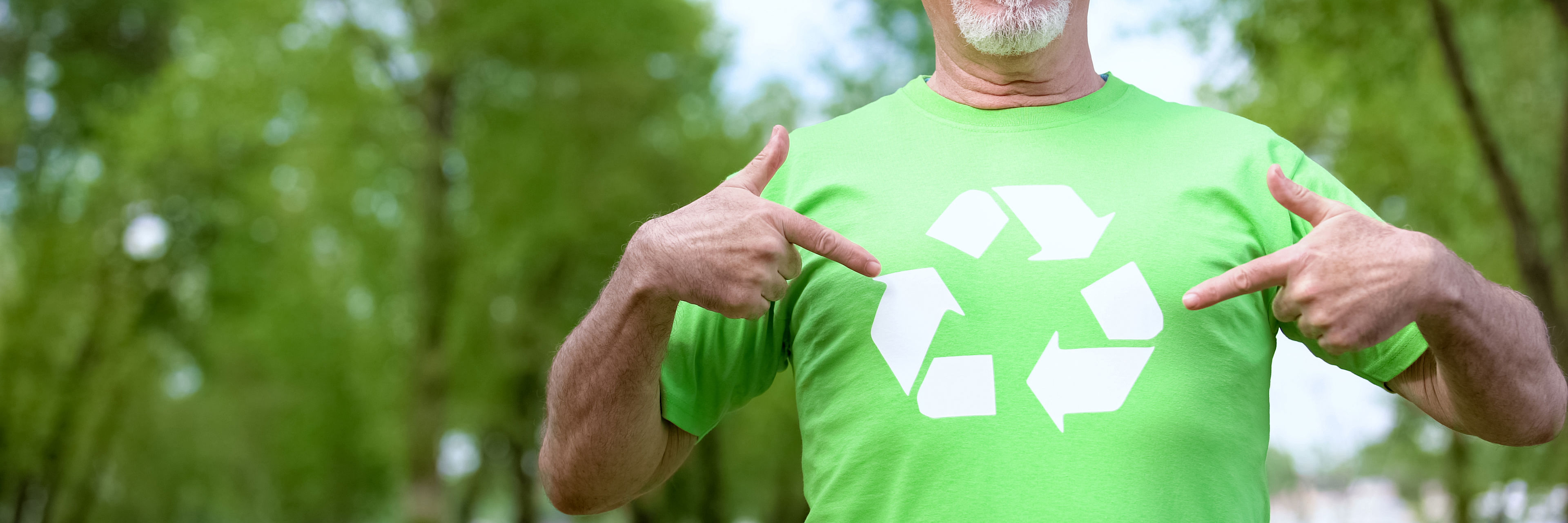 Mand peger på genbrugstrekant på sin T-shirt