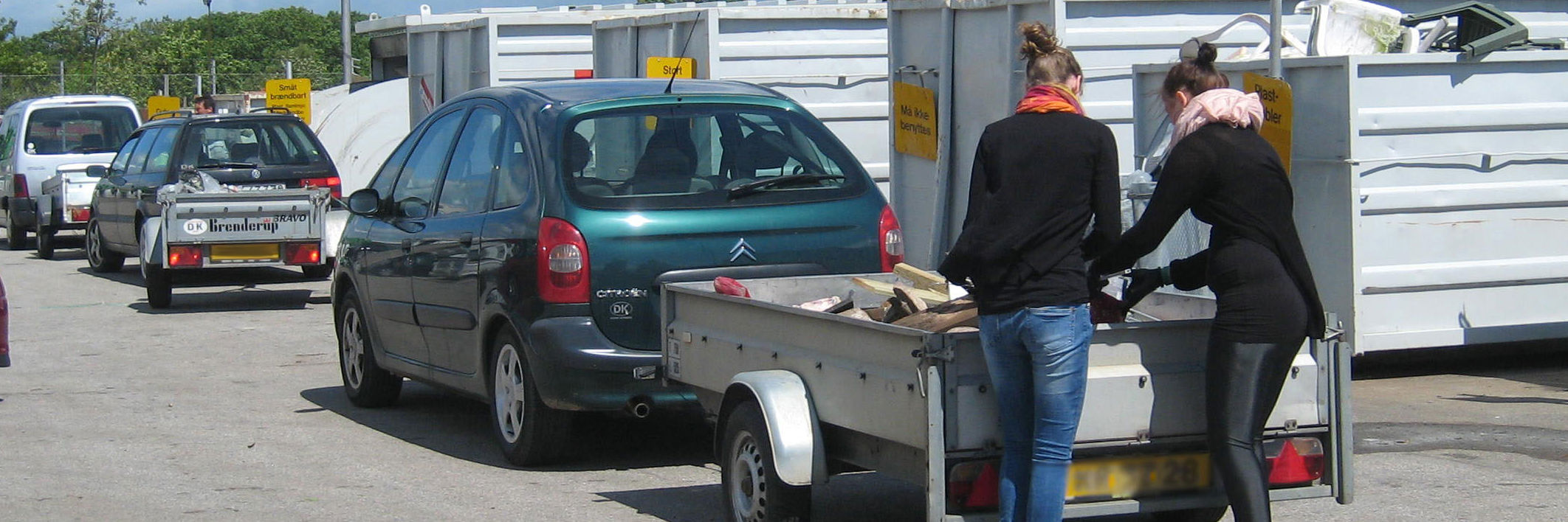 Piger tømmer trailer på genbrugspladsen