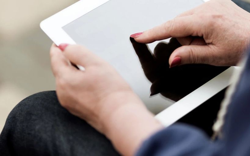 Kvinde sidder med Ipad