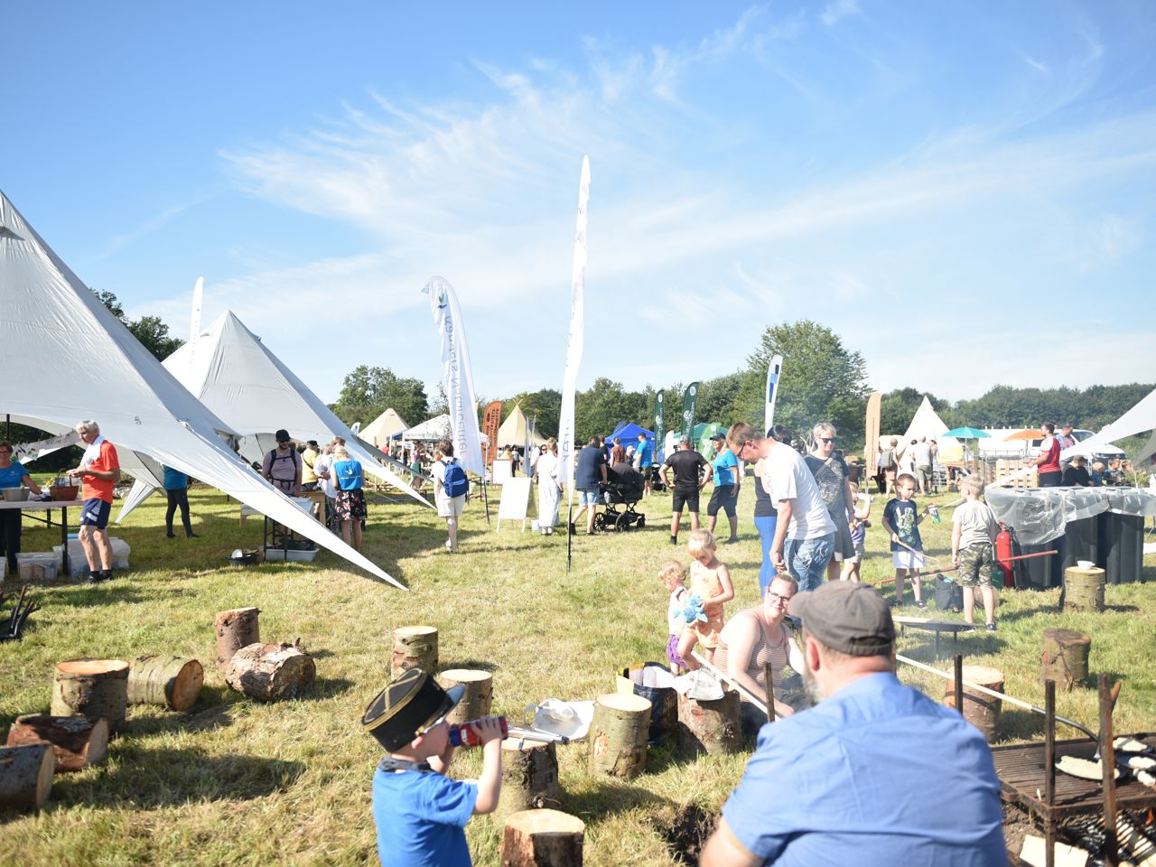 Naturfestival med græs, bål og telte.
