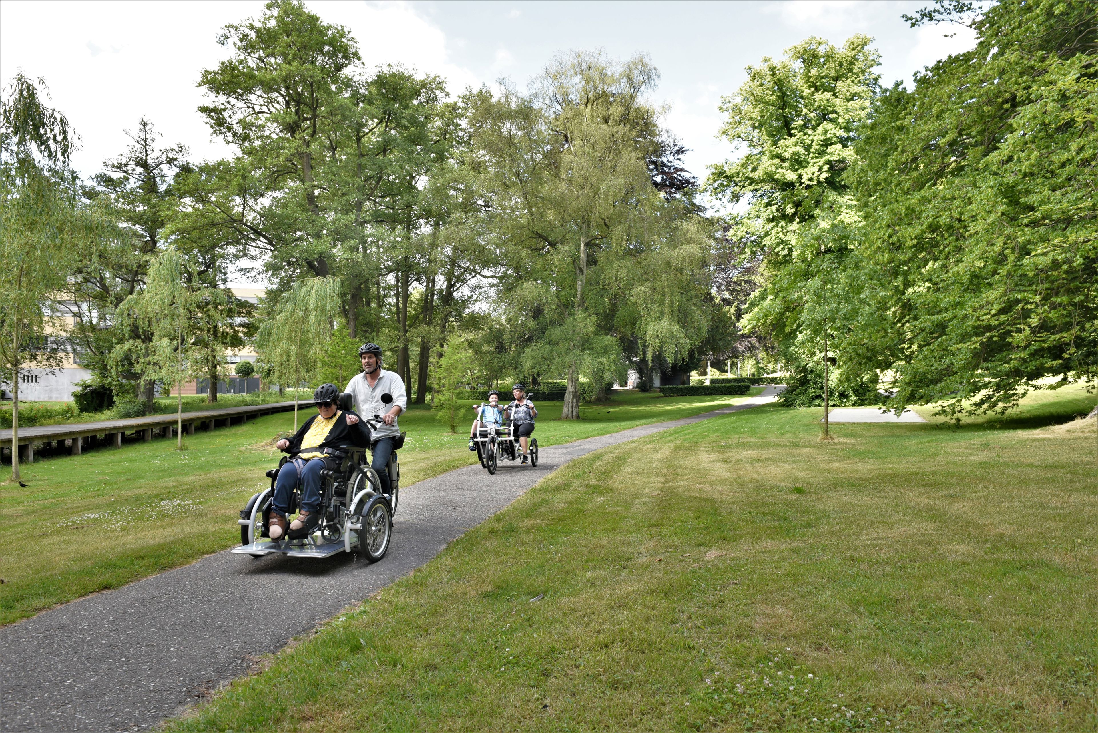 Borger i kørestol er på tur med hjælper på handicapcykel.