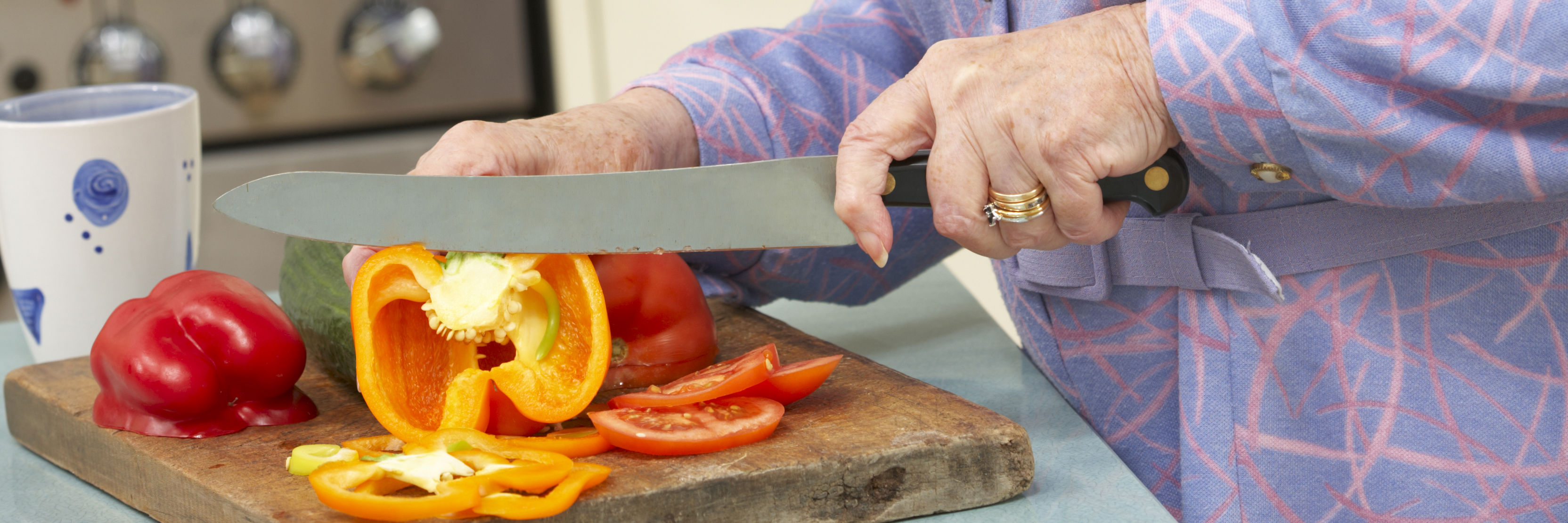Ældre kvinde skærer grøntsager