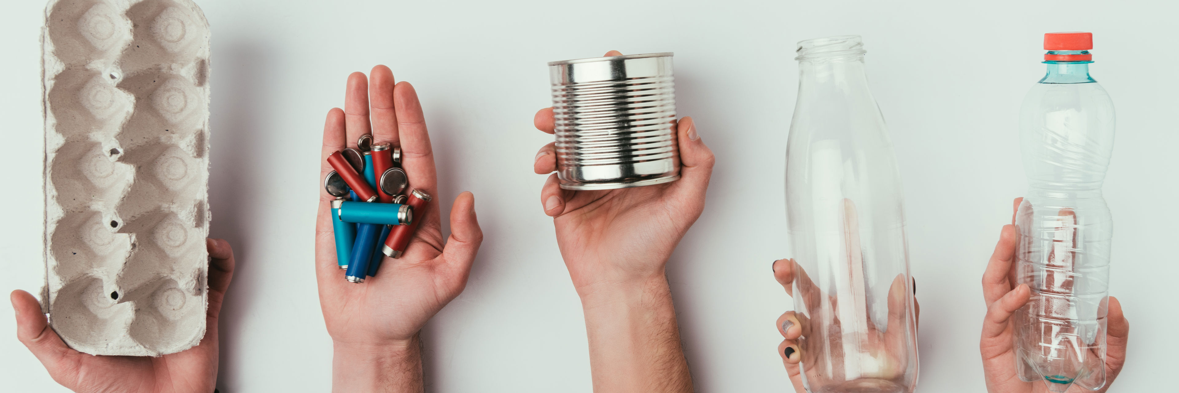 Hænder der holder forskellige slags affald